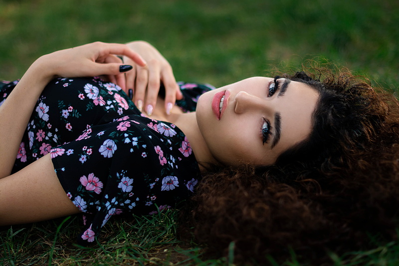 lying on back, grass, face, model, adult, young women, holding, women, leisure activity, portrait, one person, lifestyles, dress, curly hair, hairstyle