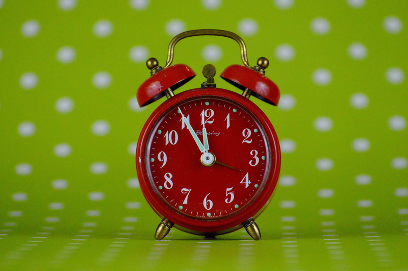 focus on foreground, checking the time, waking up, green color, the eleventh hour, disaster, minute hand, bell, red, indoors, single object, clock face