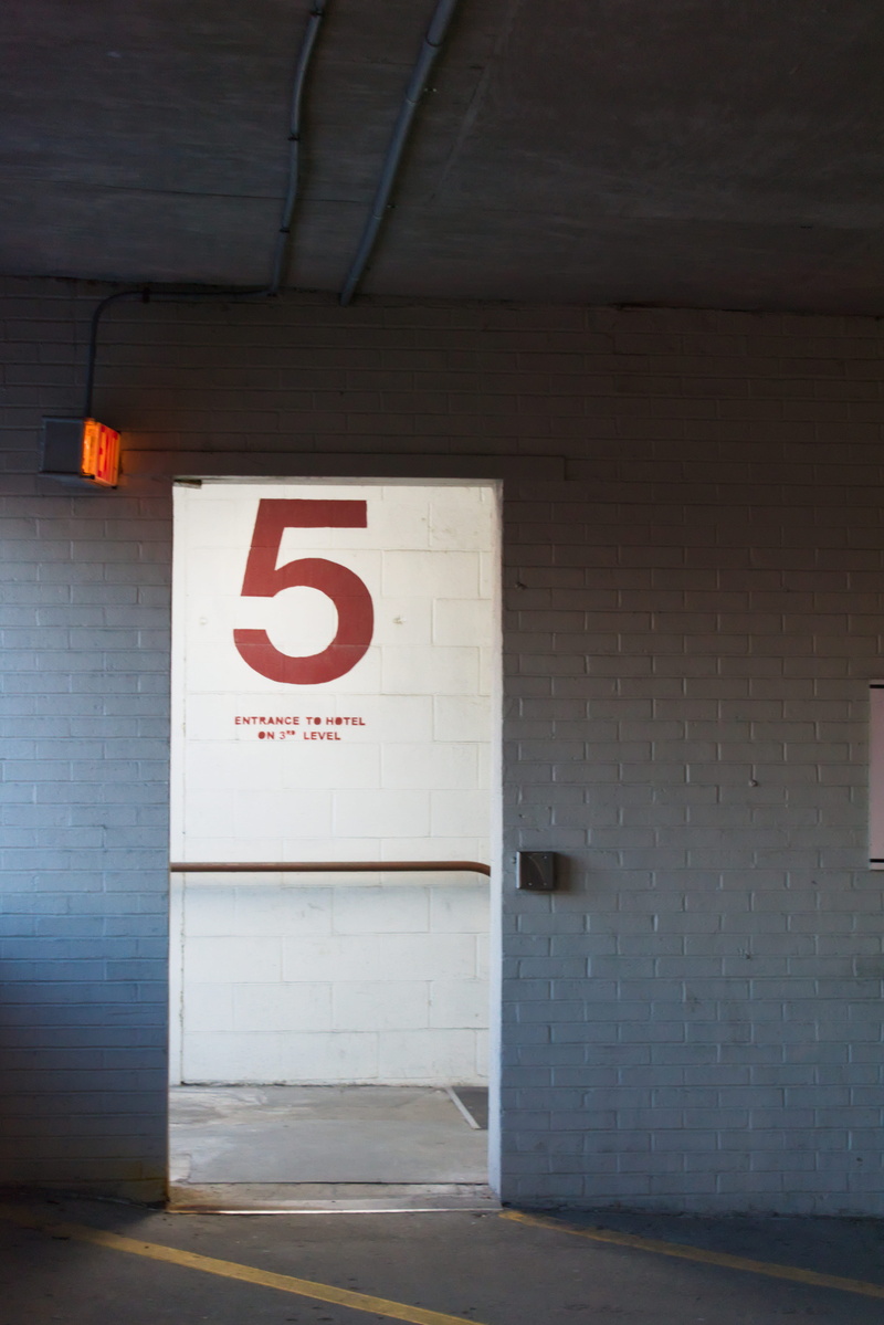 city, day, guidance, brick, wall, white, built structure, communication, parking lot, entry, indoors, entrance, information sign, parking garage, text