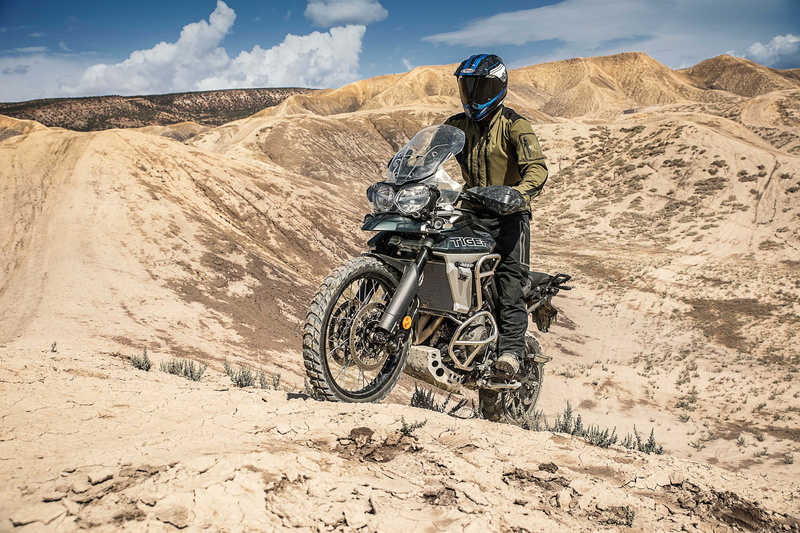 headwear, land vehicle, sunlight, mode of transportation, Triumph Tiger 800 XCA, motorcycle, sky, day, rock - object, one person, helmet, climate, crash helmet