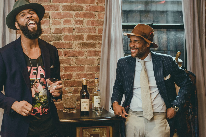 males, hat, young adult, pose, lifestyles, brick wall, smile, refreshment, alcohol, facial expression, room, facial hair, fine-looking, bottle, mustache