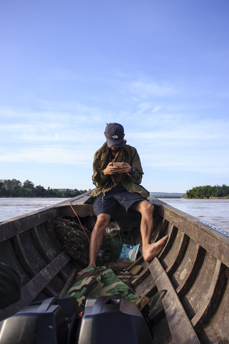cloud - sky, person, man, leisure activity, trees, sky, young adult, watercraft, background, outdoors, cellphone, lifestyles, day, front view, wear, occupation
