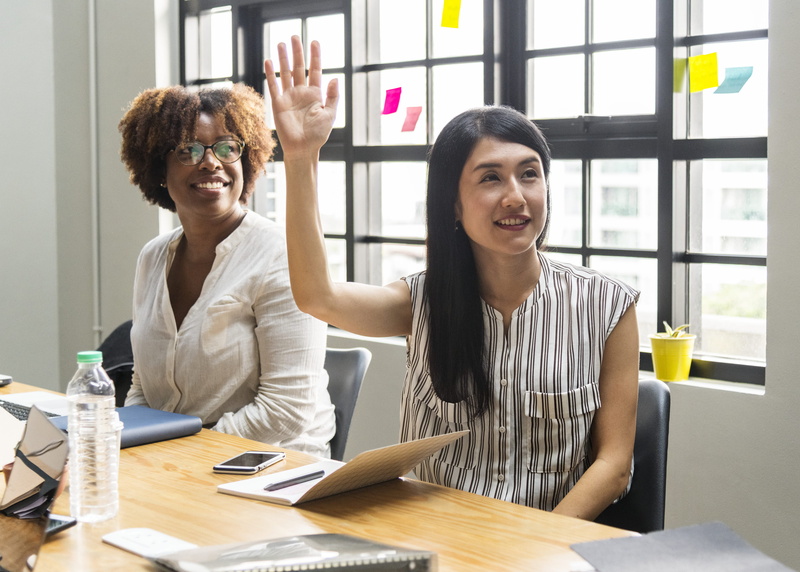 people, smiling, sticky notes, casual clothing, friends, table, eyewear, coworker, cooperation, furnitures, teamwork, workspace, notebook, communication