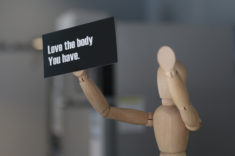 focus on foreground, figurine, wood - material, toy, female likeness, business, indoors, holding, i love your body, 5K, text, art and craft, finance, male likeness