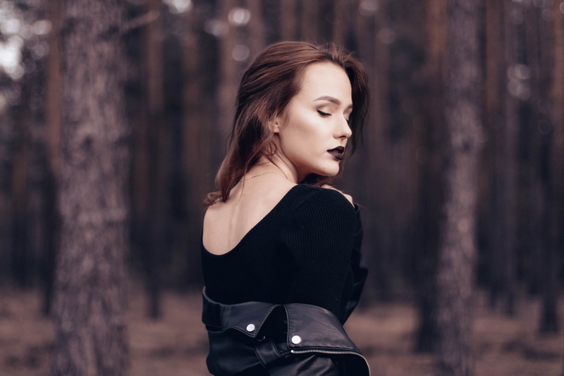 depth of field, sepia, brunette, looking away, closed eyes, trees, portrait, focus on foreground, land, young adult, black clothing, nature, beauty, beautiful woman