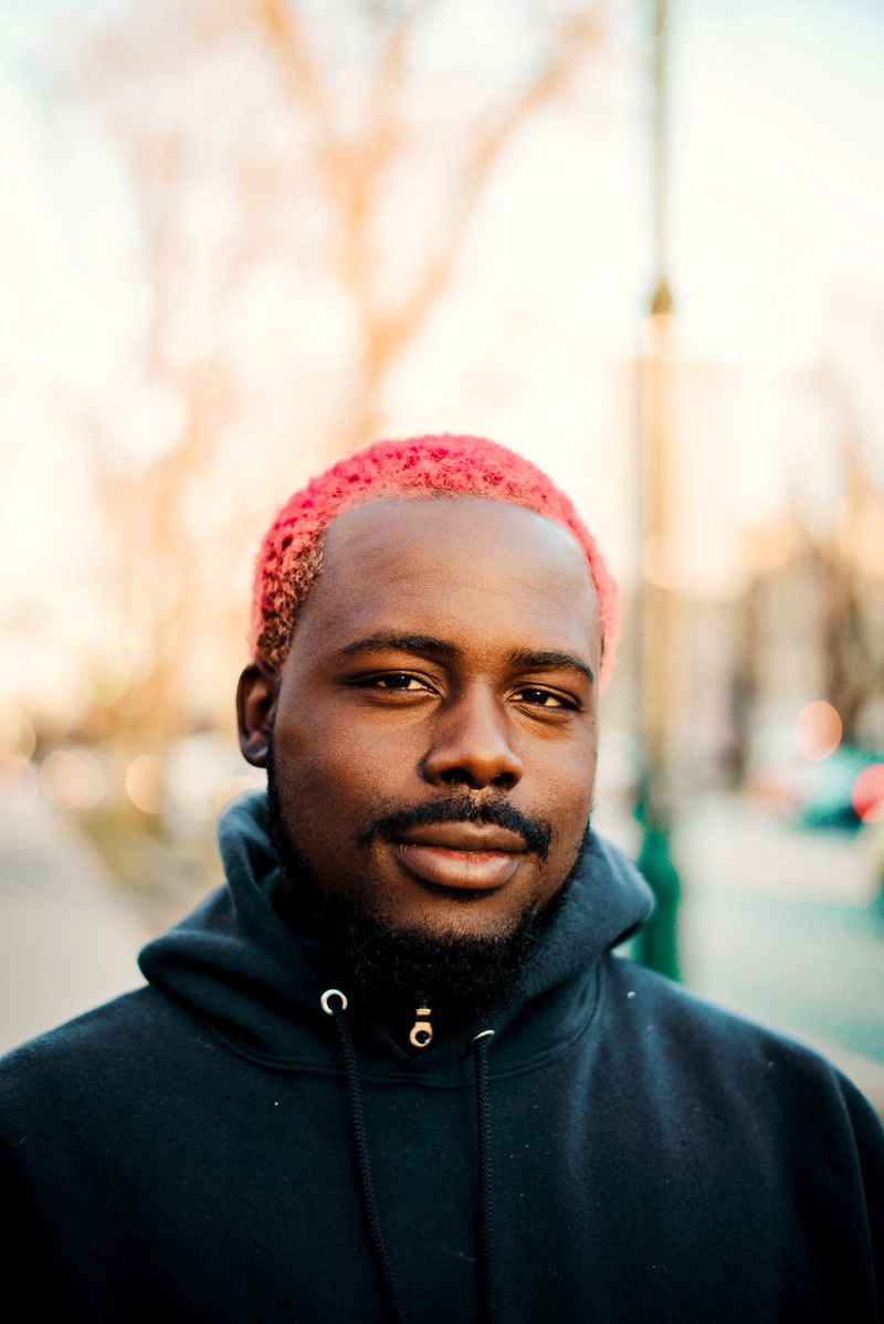 black hoodie, goatee, hoodie, beard, architecture, complex, front view, man, headshot, young men, sideway, 2K, handsome, punk, lifestyle, shallow, black man
