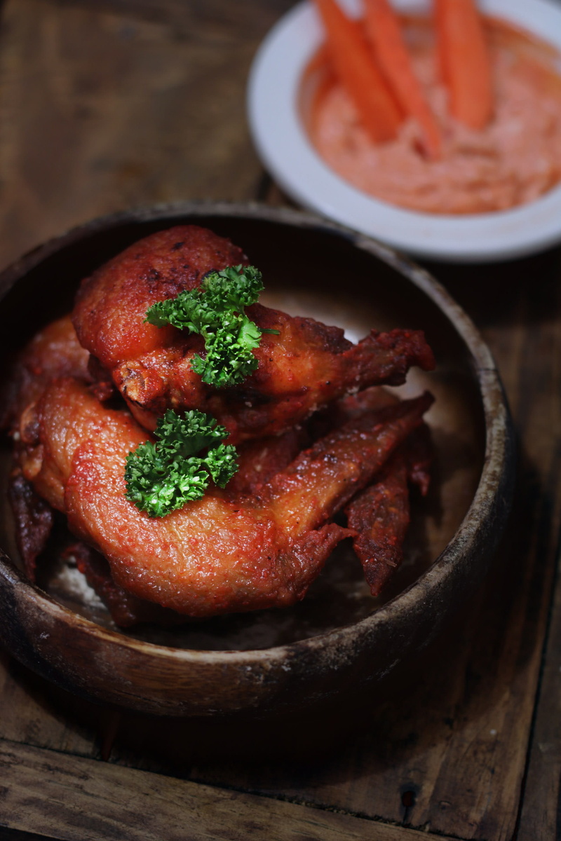 deep fried, 2K, bokeh, freshness, indoors, cook, meat, savory, fried, wings, bbq, buffalo wings, vegetable, spice, ready-to-eat, focus on foreground, frying pan
