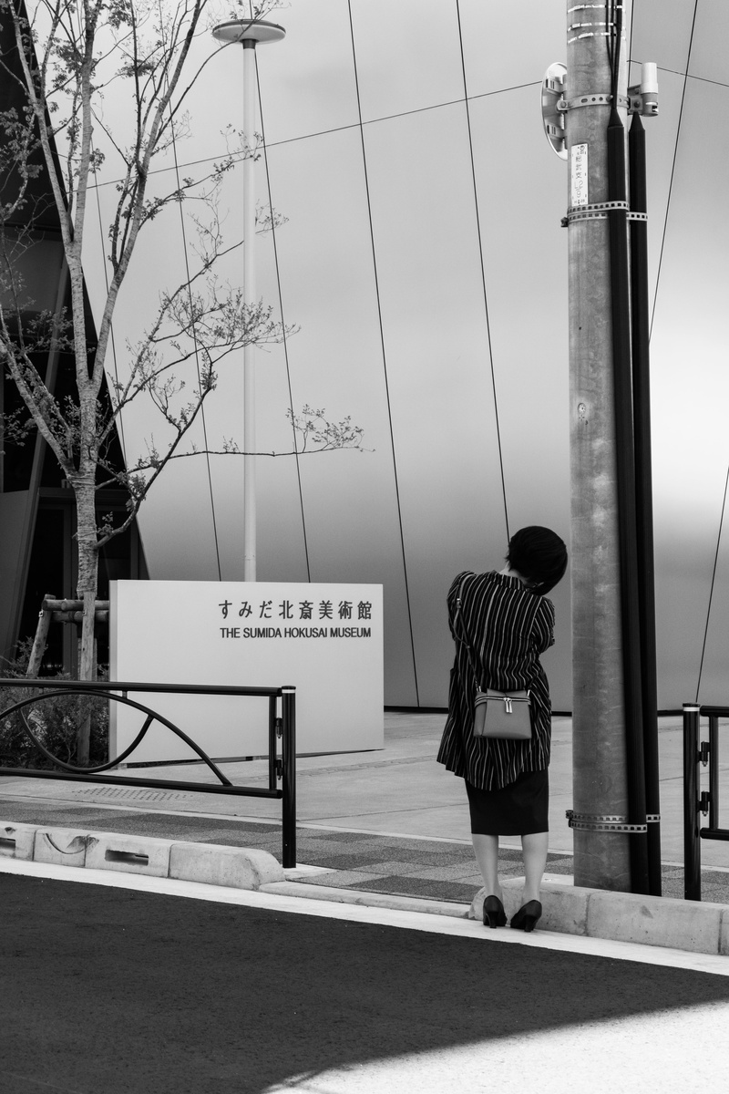 black and white, western script, architecture, person, sumida hokusai museum, technology, real people, hokusai, vehicle, road, city, outdoors, cable, post