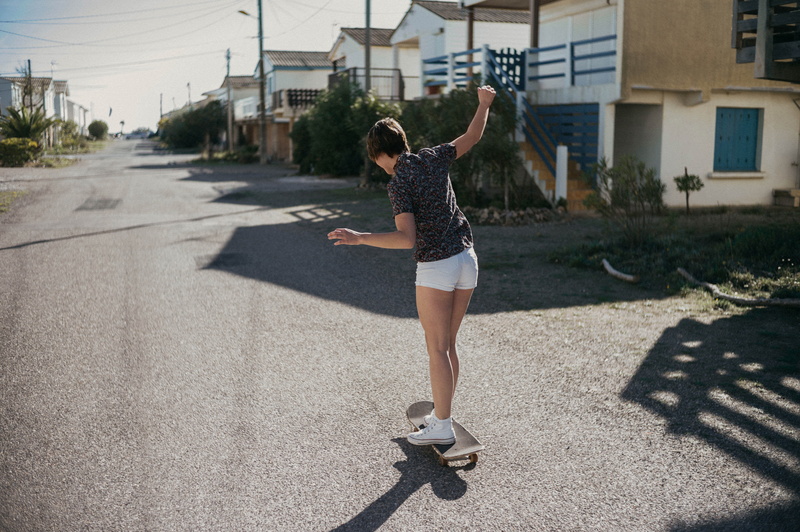 female, lifestyles, limb, sunlight, chuck, one person, building exterior, city, real people, 5K, day, skateboard, architecture, arms raised, road, outdoors