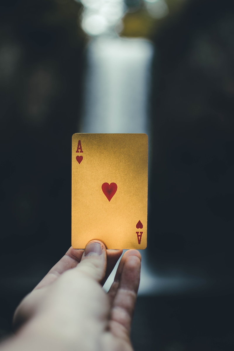 luck, real people, playing, finger, leisure games, human body part, playing card, ace, human finger, depth, hand, gold, indoors, lifestyles, mood, body part