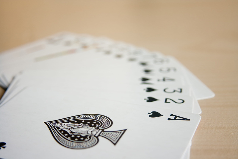 studio shot, paper, still life, table, wooden, white color, no people, indoors, poker - card game, ace, luck, order, high angle view, playing, leisure games