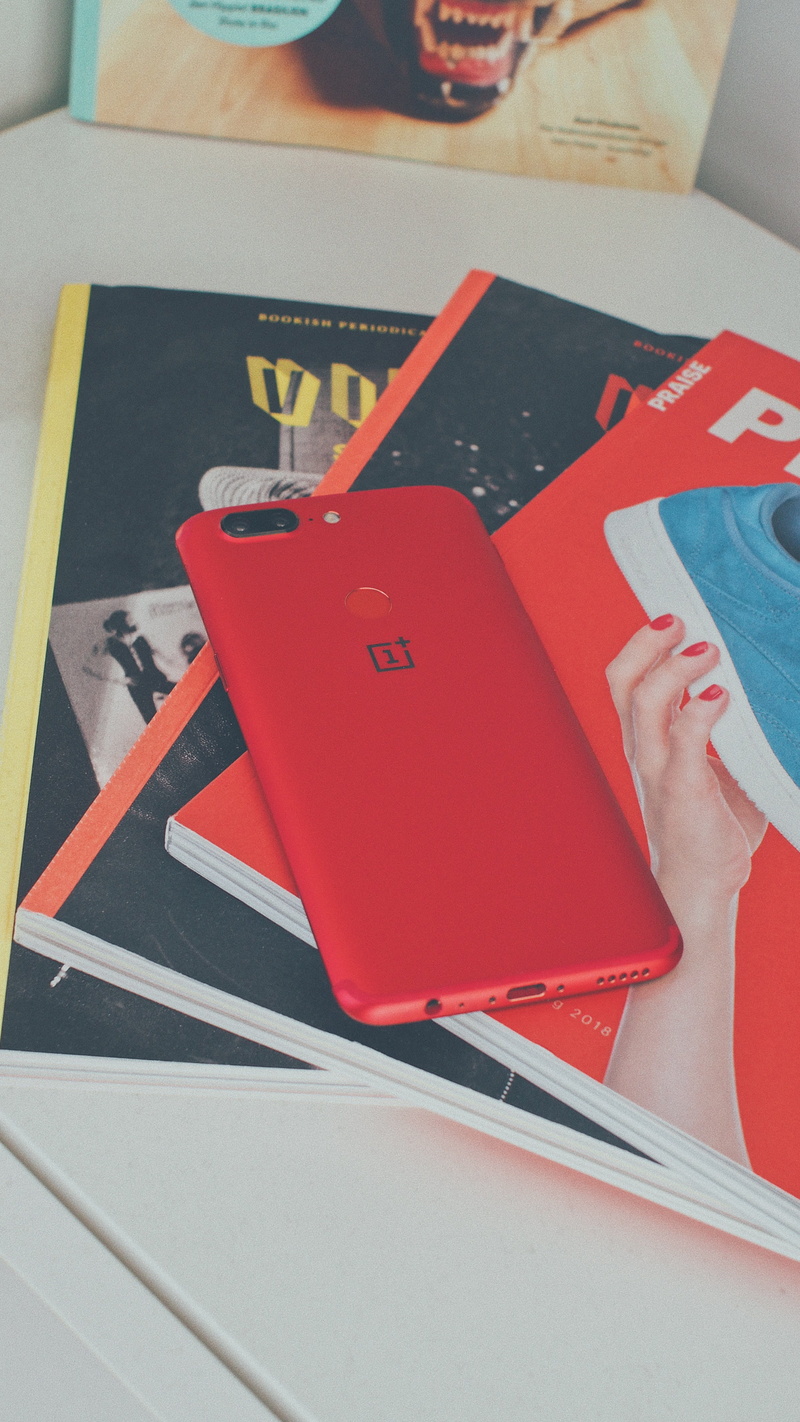 indoors, holding, human limb, back, activity, book, table, device, finger, technology, body part, logo, oneplus, electronic, books, close-up, hand, lifestyles