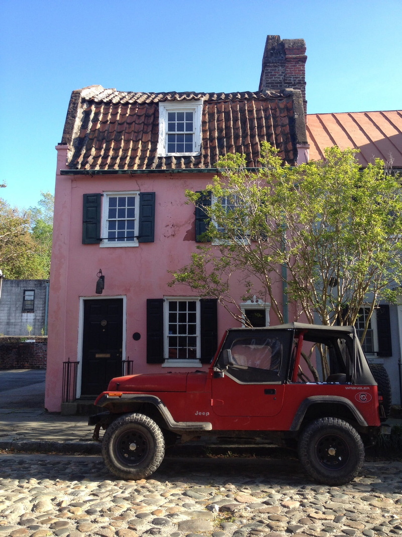 city, window, pink house, building, outdoors, motor vehicle, plant, nature, day, transportation, red, vowels, land vehicle, sky, no people, stationary