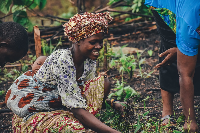 real people, women, casual clothing, 4K, child, three quarter length, holding, clothing, people, lifestyles, farming, land, mother, sitting, grass, africa
