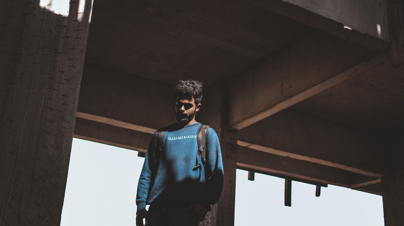 light, built structure, apparel, wearing, glasses, 5K, ceiling, home decor, adult, waist up, photography, men, clothing, man, blue, pants, handrail, human