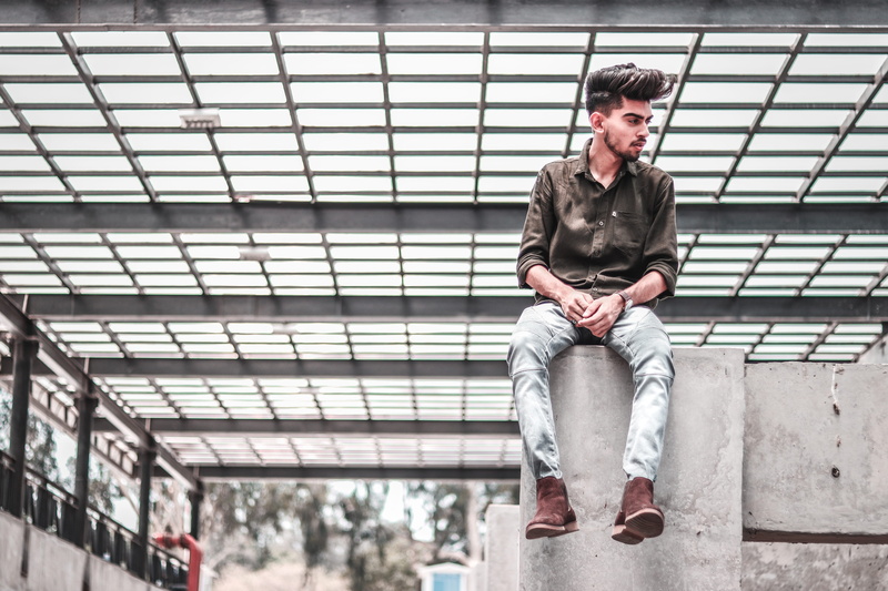 concrete, fence, one person, structure, technology, bench, real people, lifestyles, hairstyle, human, built structure, gray, boot, men, casual clothing