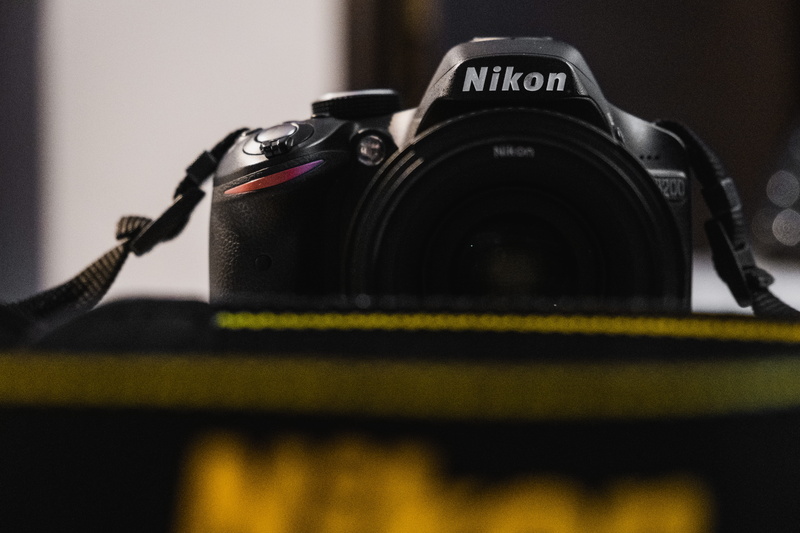 lens cap, silhouette, alloy wheel, machine, trademark, photographic equipment, finger, aircraft, video camera, electronics, cable, symbol, camera, strap
