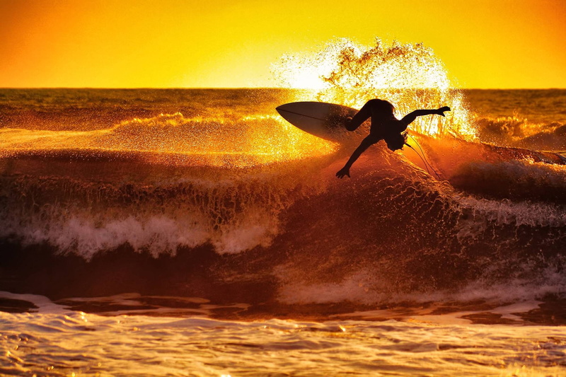sea, sunset, leisure activity, nature, surfboard, water, wave, extreme sports, motion, sky, skill, orange color, sport, people, outdoors, aquatic sport
