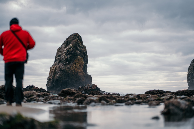 standing, rock, lifestyles, man, real people, 5K, cloudy, rock formation, landscape, shore, water, beach, hat, red, hoodie, promontory, outdoors, shoreline