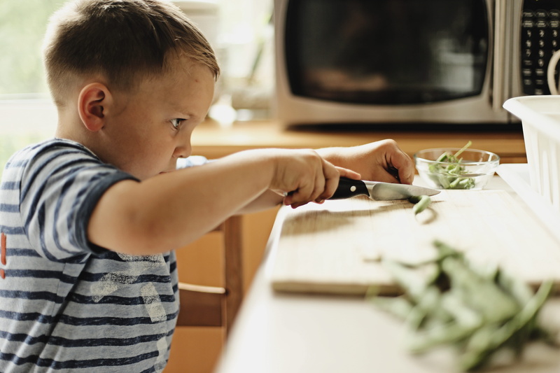 t-shirt, childhood, pod, food, helping, home interior, concentration, waist up, holding, stare, child, boys, string, indoors, chop, kitchen, domestic kitchen